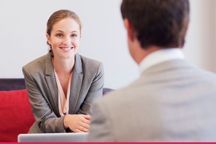 Two people in a meeting smiling