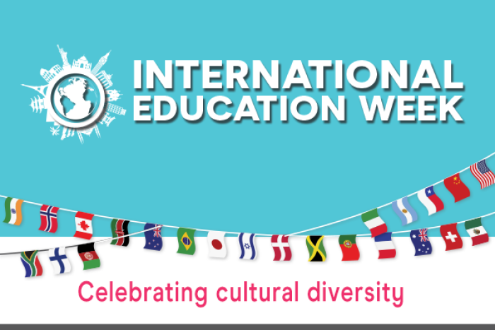 Turquois background, many international flags across the poster, bold letters say International Education Week  