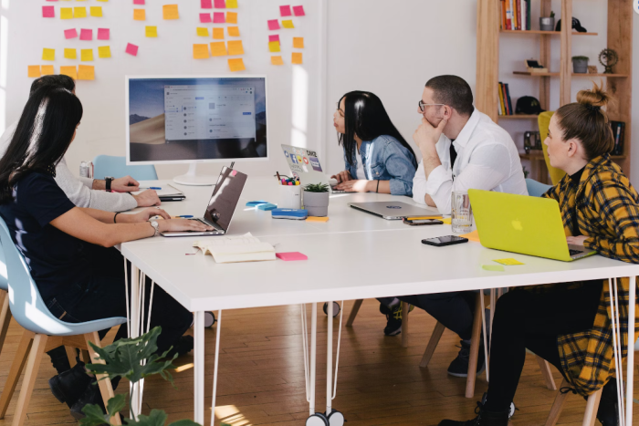 upbeat office meeting, five people look at a presentation