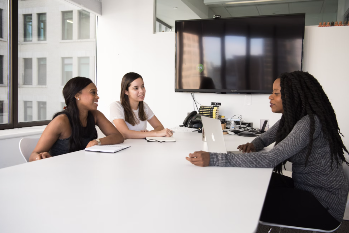 Three women sit in a meeting together