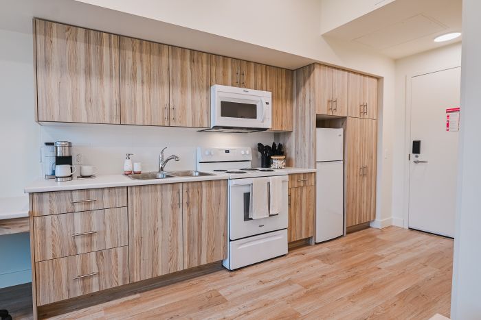 A fully equipped kitchen with appliances, countertops, and ample storage along one side of the room.