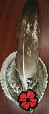 Eagle feather, Rhea's smudge shell and beaded poppy.