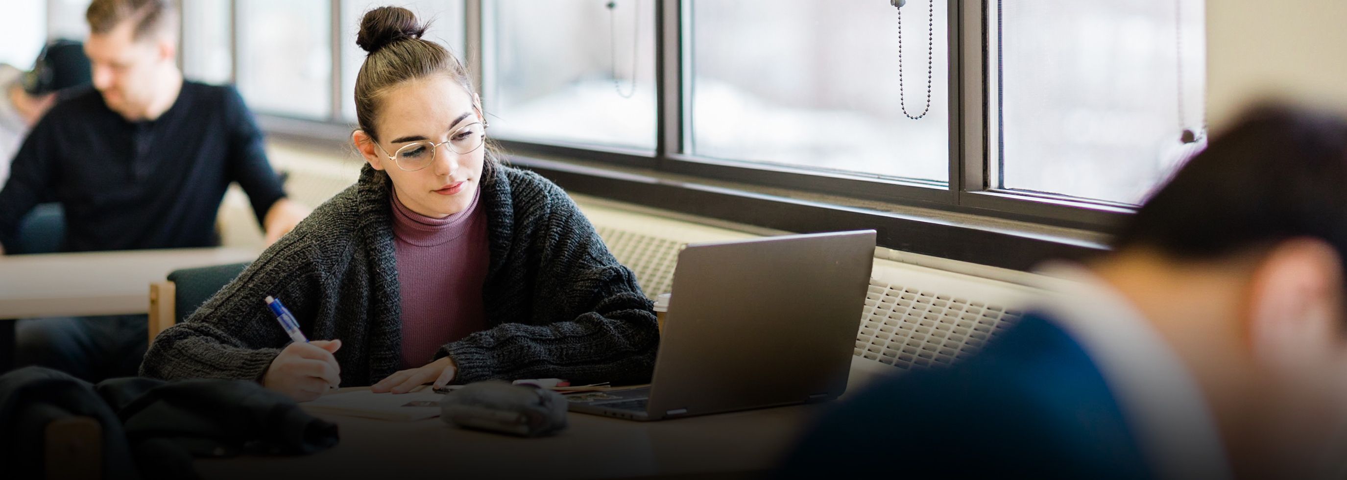 Student sitting at a desk with a laptop open