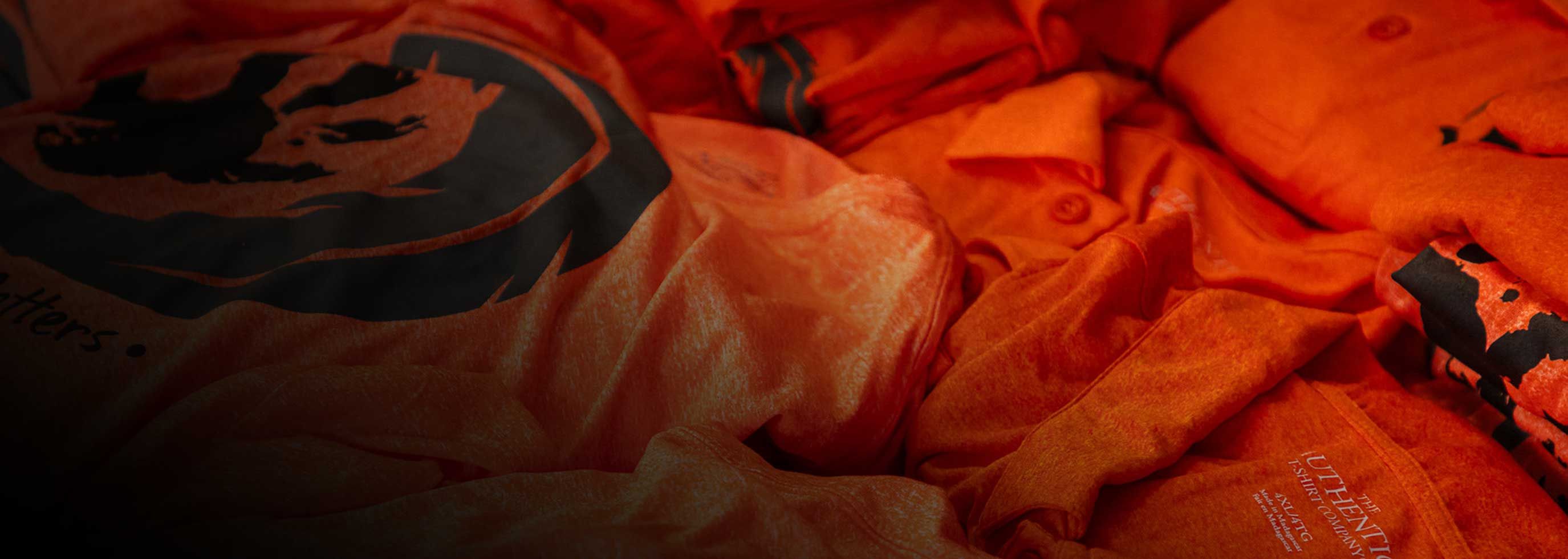 Table of folded Every Child Matters orange shirts for Truth and Reconciliation day