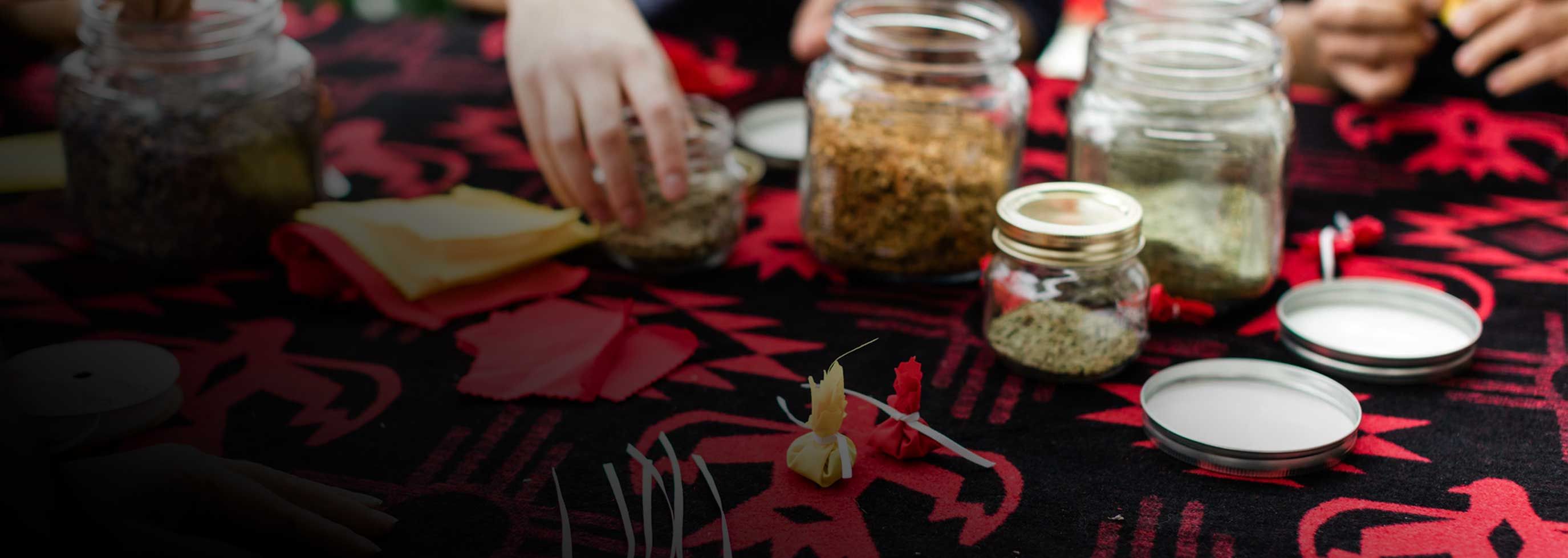Image of table covered with Indigenous blanket and jars with dried plant material for a workshop