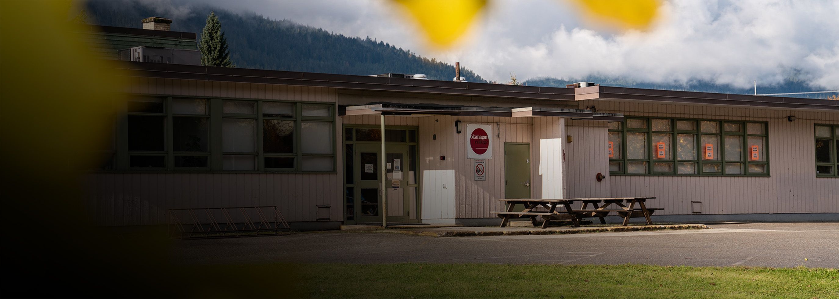 Image of the exterior of Revelstoke Centre building with leaves in foreground