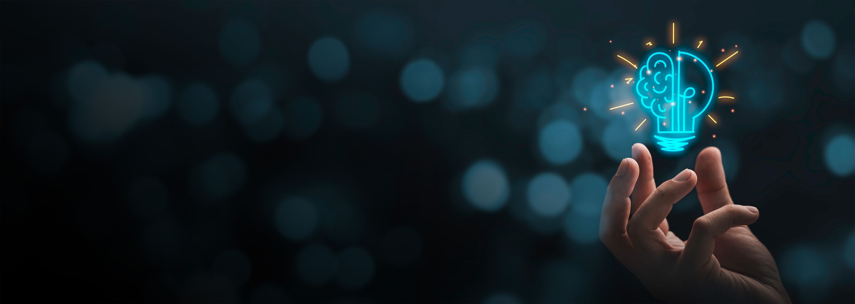 Hand holding graphic of lightbulb that is half lightbulb half brain