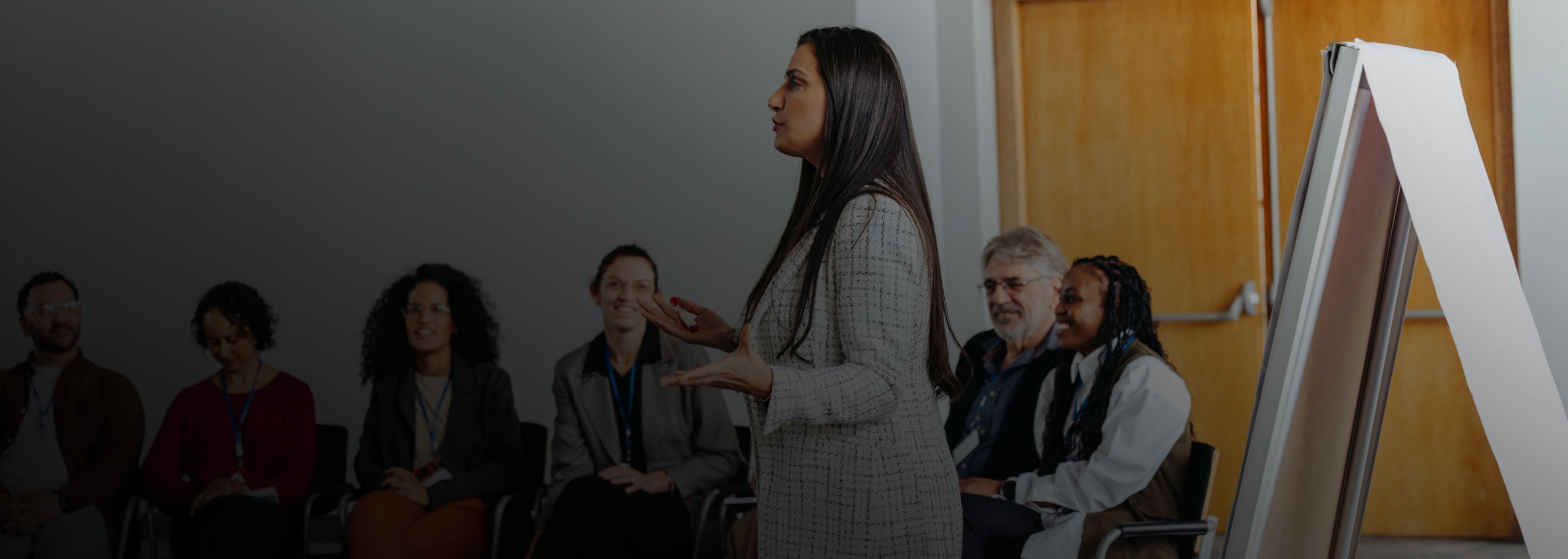 A woman public speaking with a crowd.