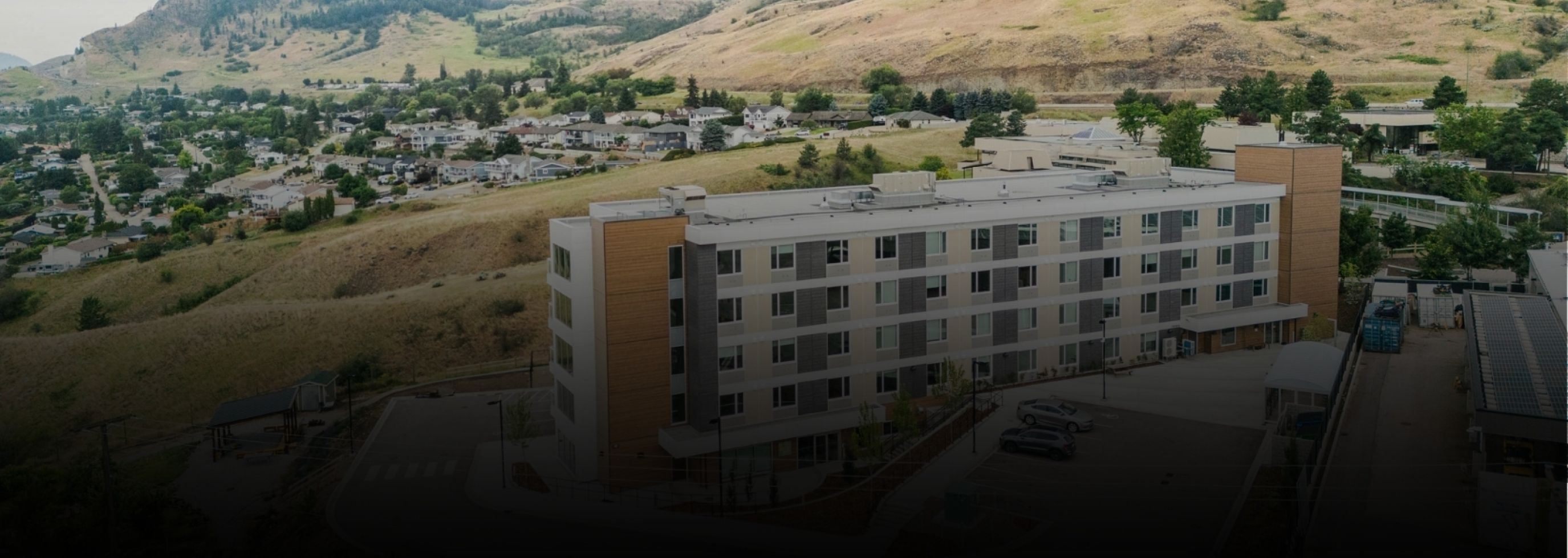 Exterior view of the student housing building overlooking the surrounding Okanagan landscape.