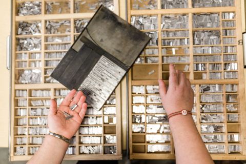 Hands sorting through letter press lettering