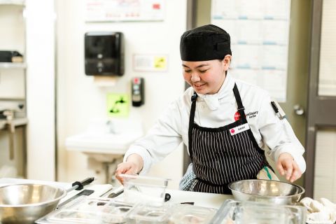 student in kitchen preparing meals