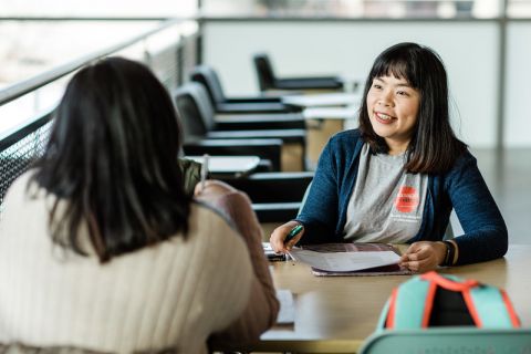 two students sitting across a desk from each other