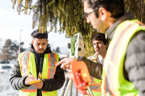 three student in high-visual vests working outside