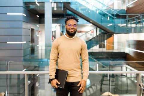student standing with books inside