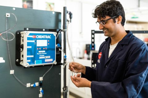 male student standing with water technology