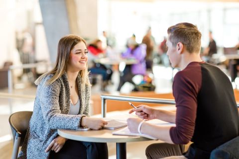 two students sitting in the atrium working