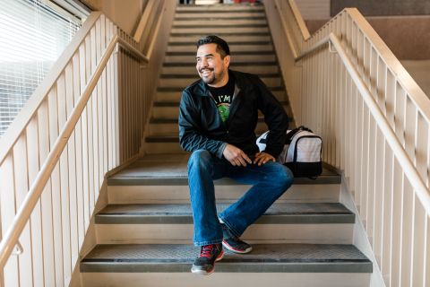 Adult upgrading student takes a break by sitting on the stairs and looking out the window