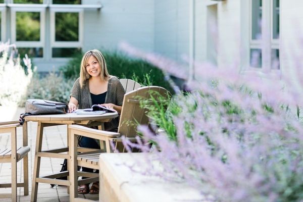A student smiles while holding a new laptop donated by Staples.