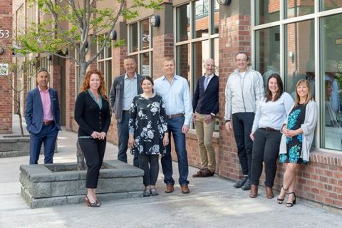 The Kelowna Homelessness Research Council members stand in front of a brick building