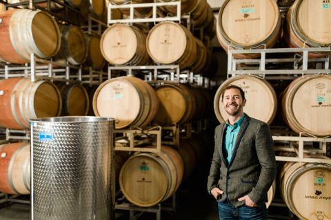 A male student in the Viticulture certificate program stands inside the wine cellar at Tantalus winery.