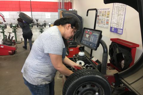 women using tire change over equipment in automotive shop