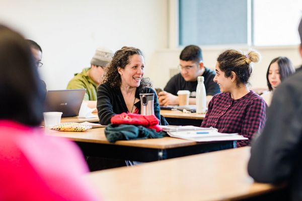 ESL instructor sitting with a student at their desk