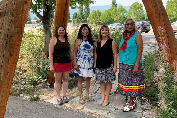 Four people standing in the Indigenous garden at the Kelowna campus
