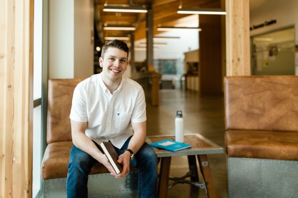 Male student sitting in a nice little study nook with his books.