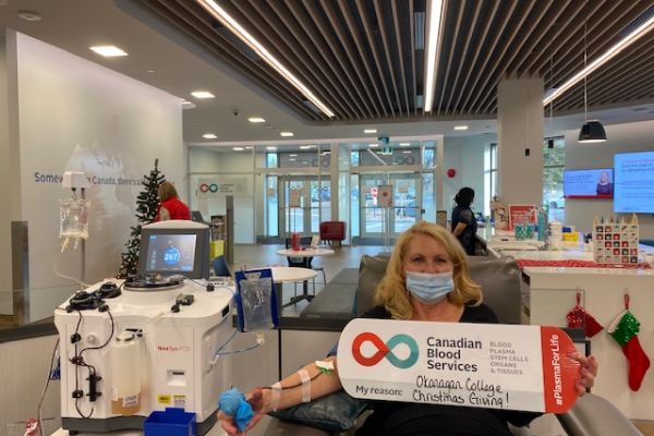 An Okanagan College employee is pictured donating blood 