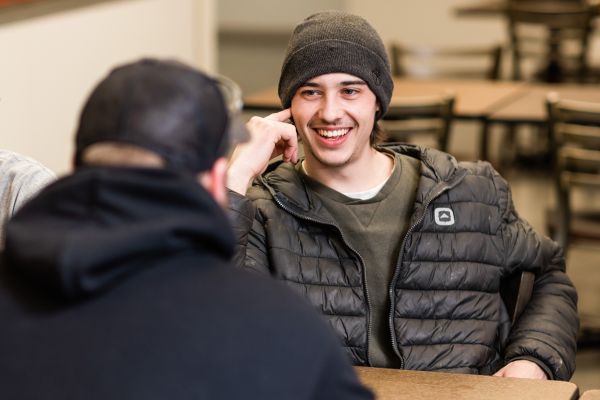 two students sitting at a table in the trades training atrium