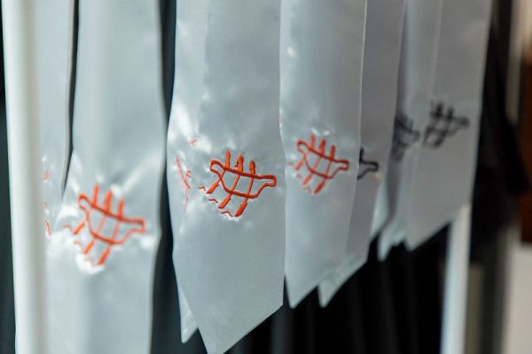 Indigenous stoles showing a pictograph of three people in a canoe
