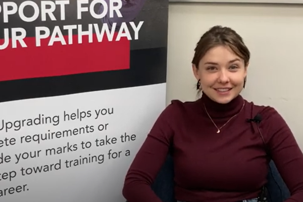 Beatriz sits next to an upgrading banner