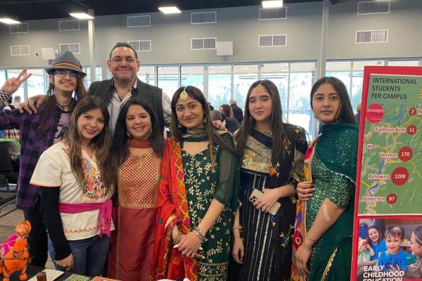 A group of students wearing traditional clothing pose for a photo