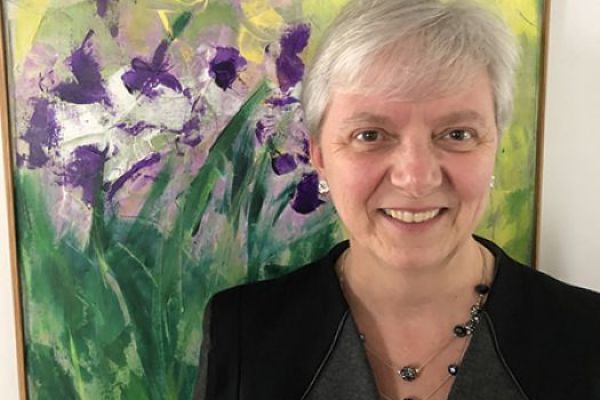 meri kim oliver standing in front of framed artwork