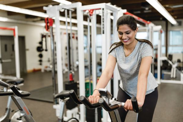 An student rides a stationary bike in OC's recreation centre in Penticton.