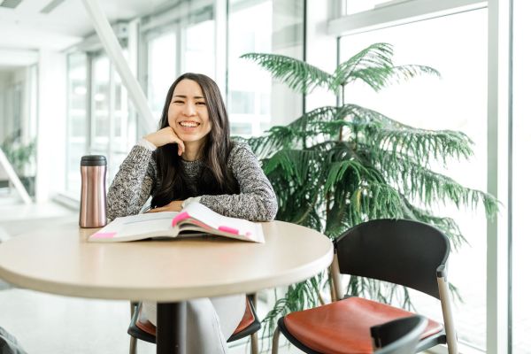 Student smiling while studying at OC's Kelowna campus.
