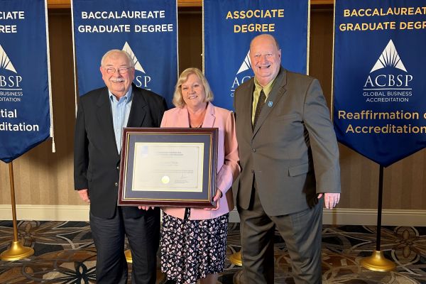 OC ACBSP Champions/Faculty members Laura Thurnheer (middle) and Michael Conlin (left) receiving the re-accreditation certificate from Chief Accreditation Officer for ACBSP Steve Pascale (right).