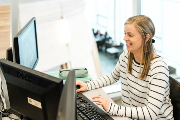 Female student working at computer smiling