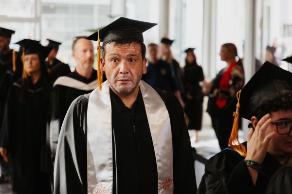 Indigenous student in white convocation stole