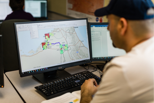 Male student sitting at desktop computer looking at digital map
