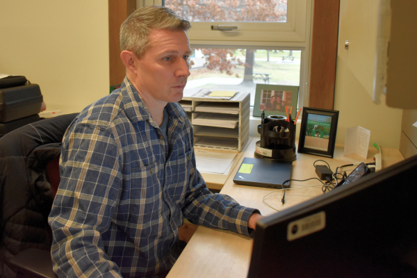 Researcher and professor Colin Wallace at his computer in office
