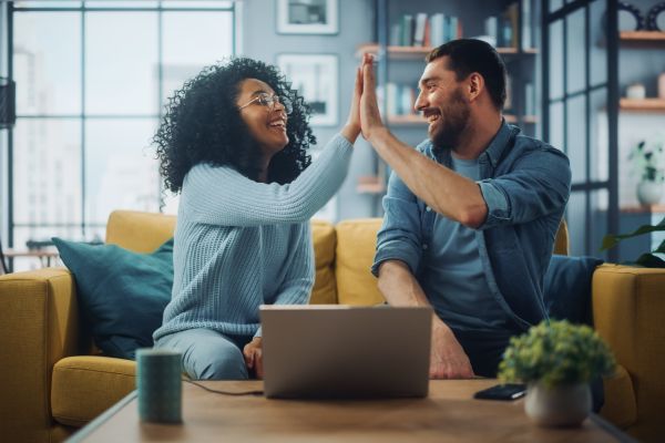 Two people sitting together and giving each other a high five