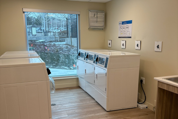 Student laundry room with washers, dryers, and large window.