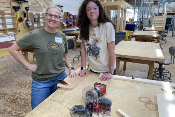 two females excited about carpentry and working on a wooden charcuterie board