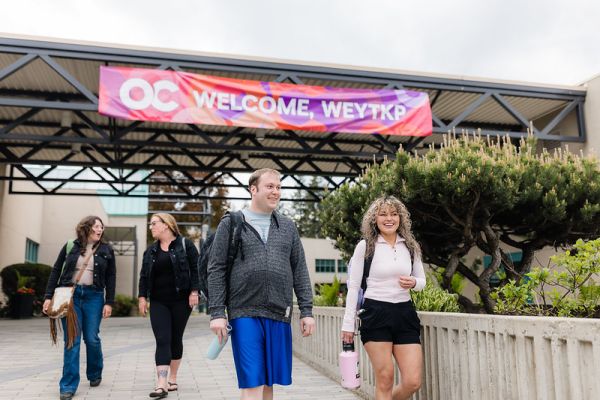 Group of students with a welcome sign behind them