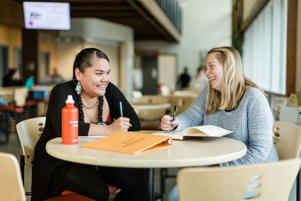 Students sitting side by side smiling
