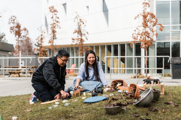 A man and woman playing with a child in the park