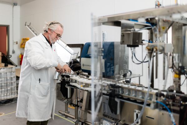 A lab technician at BC BTAC works with a new test batch canning line.