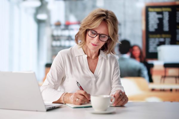 Older woman multitasking at a cafe