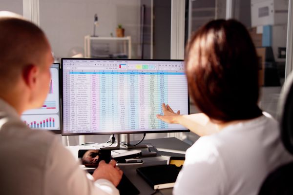 Two people collaborating and discussing a spreadsheet